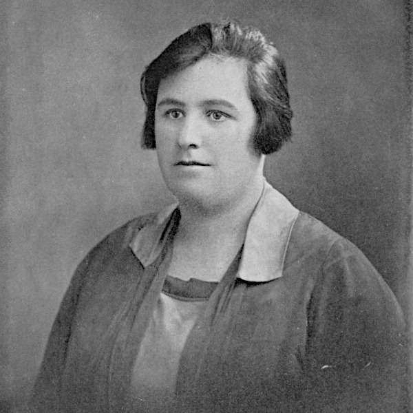 A black and white studio portrait photograph of a young Helen Duncan from the chest up, set against a neutral, softly textured background. She has short, dark hair styled in a bob and is looking slightly away from the camera. She wears a dark jacket or cardigan over a light-colored blouse with a prominent collar.