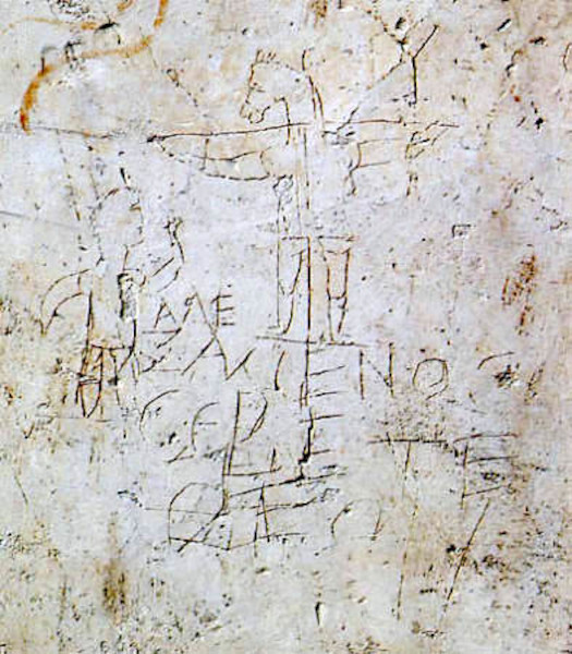 An ancient Roman plaster graffito known as the Alexamenos Graffito, showing a crude line drawing of a man worshipping a crucified figure with the head of a donkey, accompanied by Greek text.