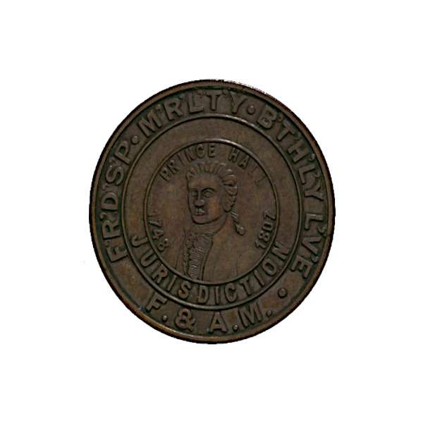 A close-up photograph of a circular bronze Masonic medallion. The inner ring features a relief profile portrait of abolitionist Prince Hall, surrounded by his birth and death years, 1748 to 1807. The outer ring displays the initials for Friendship, Morality, and Brotherly Love alongside classic Masonic square and compass emblems