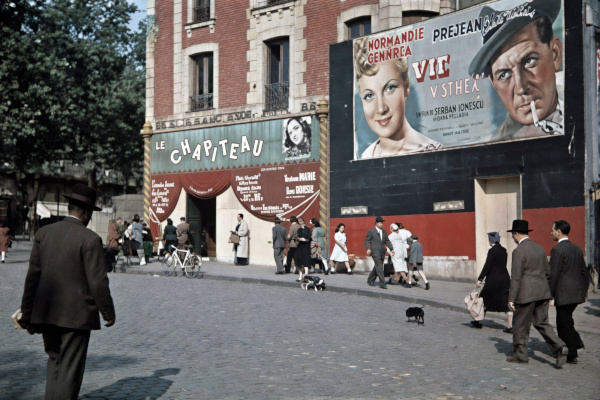 Color photograph of the exterior of Le Chapiteau at 1 Place Pigalle during the Occupation, featuring a circus-tent facade, pedestrians, and a large movie poster for the film "Vie de Bohème."