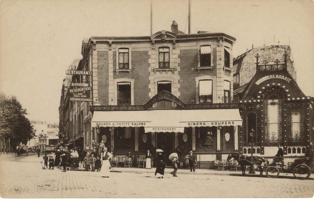 Sepia-toned vintage postcard of the exterior of l'Abbaye de Thélème at 1 Place Pigalle, showing the restaurant's white awnings, outdoor seating, and a horse-drawn carriage.